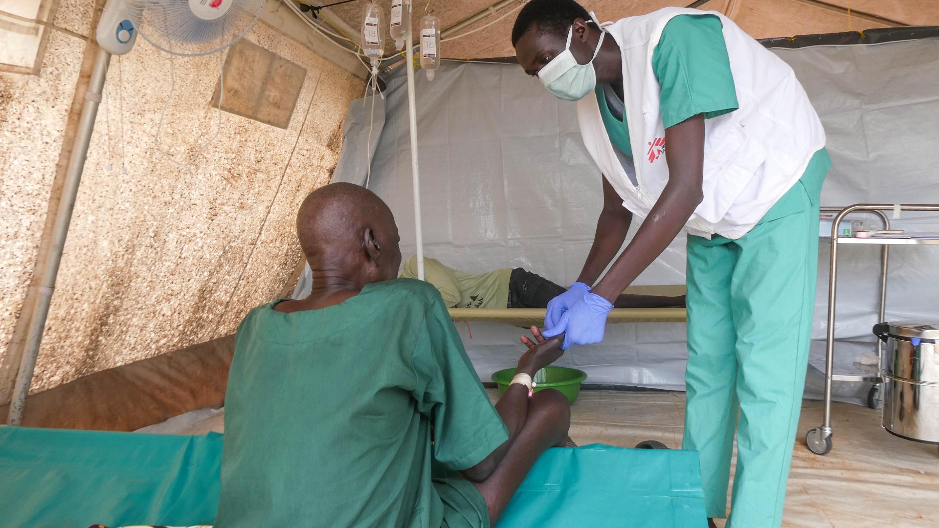 A Médecins Sans FrontièreMSF clinician treating a cholera patient inside the cholera treatment centre in Abyei during the outbreak response.s (MSF) clinician provides medical care to a cholera patient at MSF’s treatment centre in Abyei, as part of the emergency response to the ongoing outbreak.