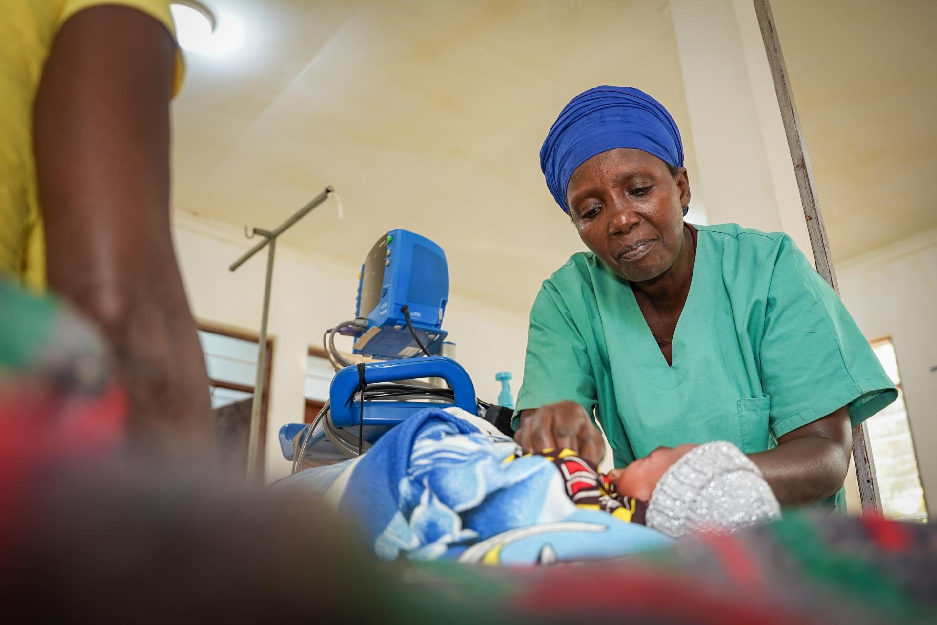 Nurse aide, Ndayumvire Antoinette attending to a child in the maternity ward at the MSF Hospital in Nduta Camp