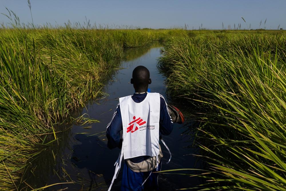 An MSF staff working in Kok island make his way back towards a MSF helicopter food drop in the troubled Unity State in South Sudan. 