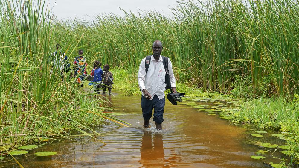 MSF paramedicine nurse Ghan Paul Hoth walks through floodwaters