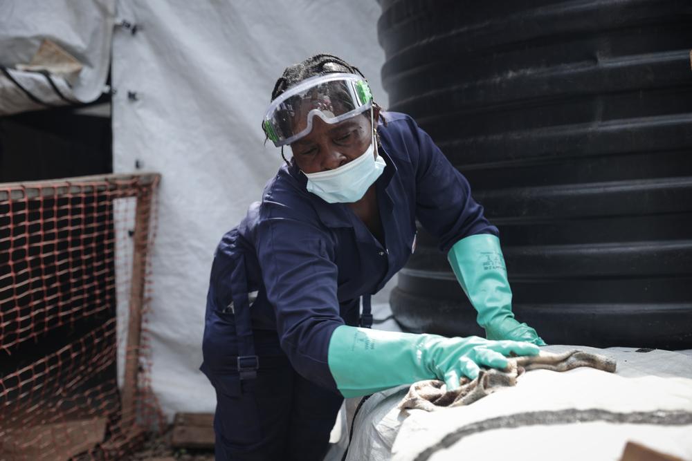 A hygiene worker disinfecting and cleaning the new cholera treatment centre to strengthen the outbreak response in South Kivu.