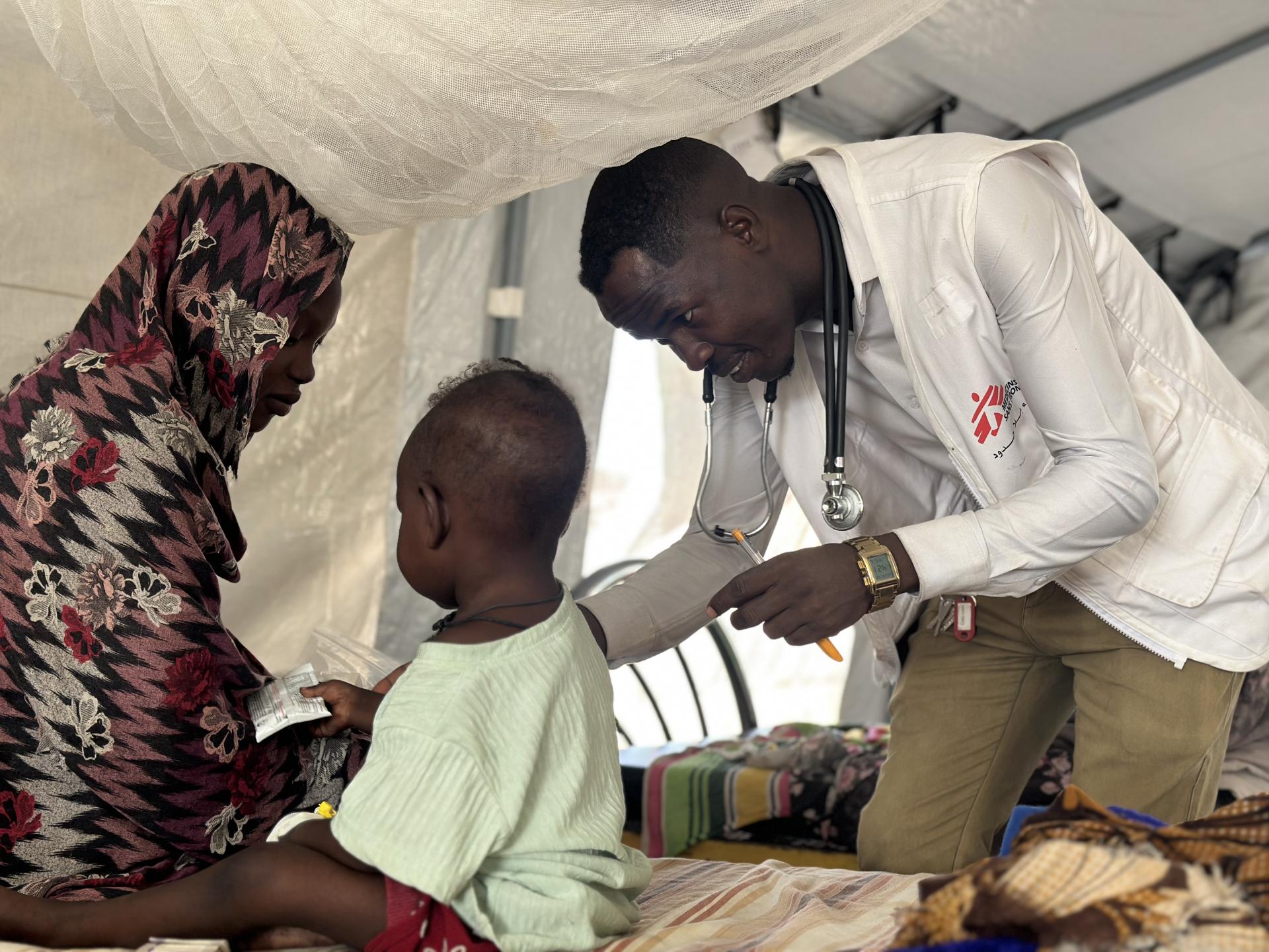Mustafa Omer Idriss, Sudanese doctor and MSF Medical Activities Manager, examines a child in Tawila Hospital.