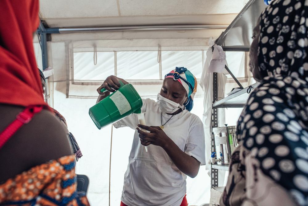 Safaratu Tambaya, nutrition support officer, pours therapeutic milk into containers for patients at 