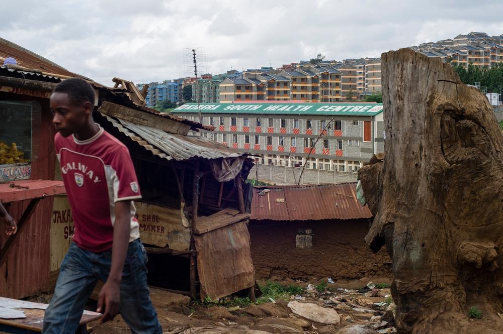 2014: A man walks past a small, tin-roof shop in the Kibera slum, near Kibera South Health Centre