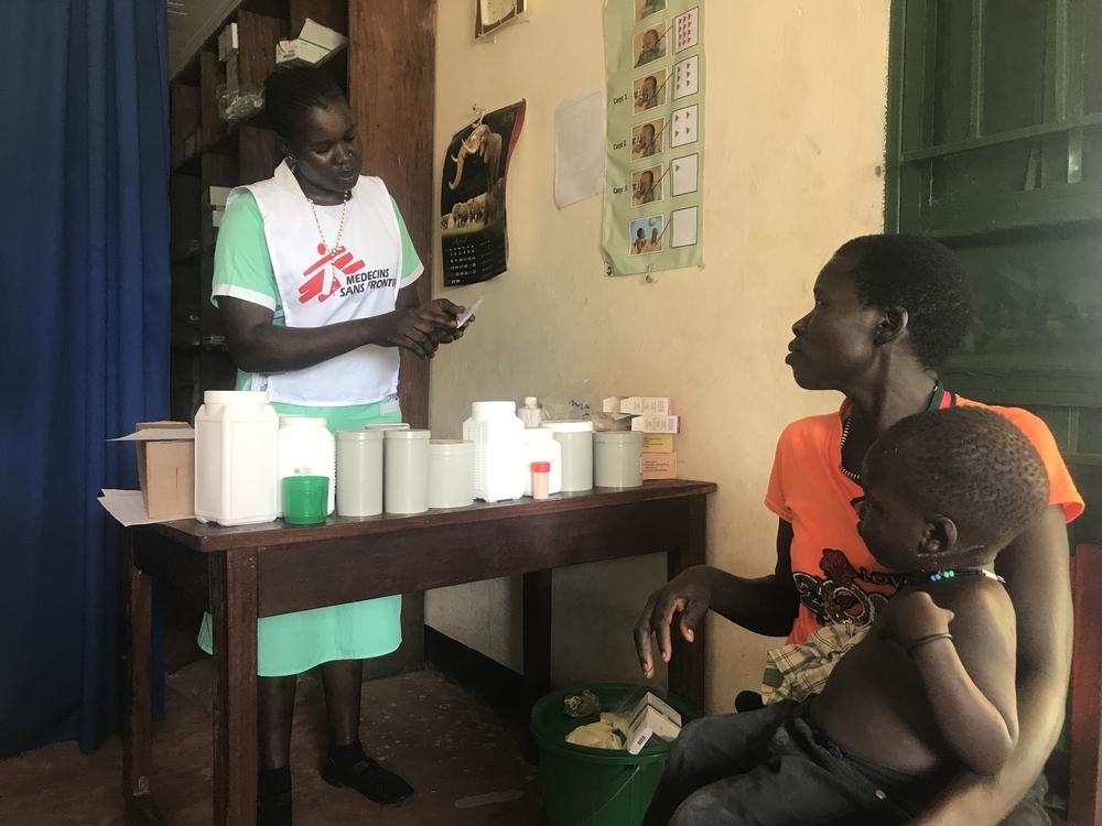 MSF Nursing Care Provider Abau Susan issues medication & explains its use to a mother