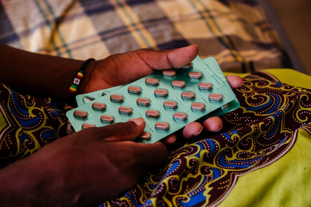 Ether, an advanced HIV patient in Malawi, with her medication in her hands