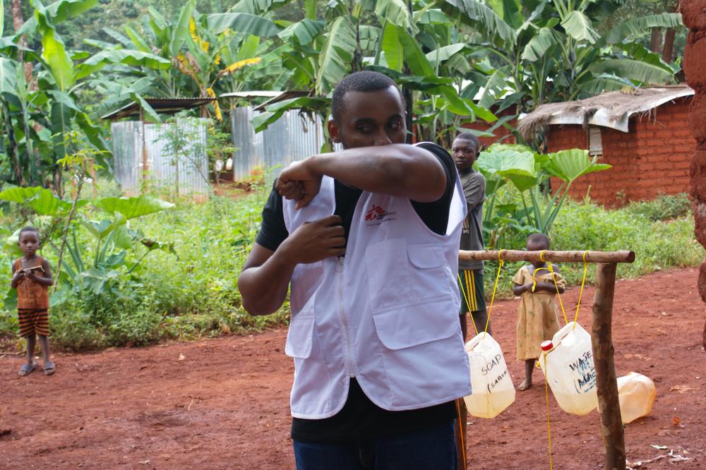 Tumaini Kombe, focal point for health promotion in Nduta explaining sneeze & cough etiquette