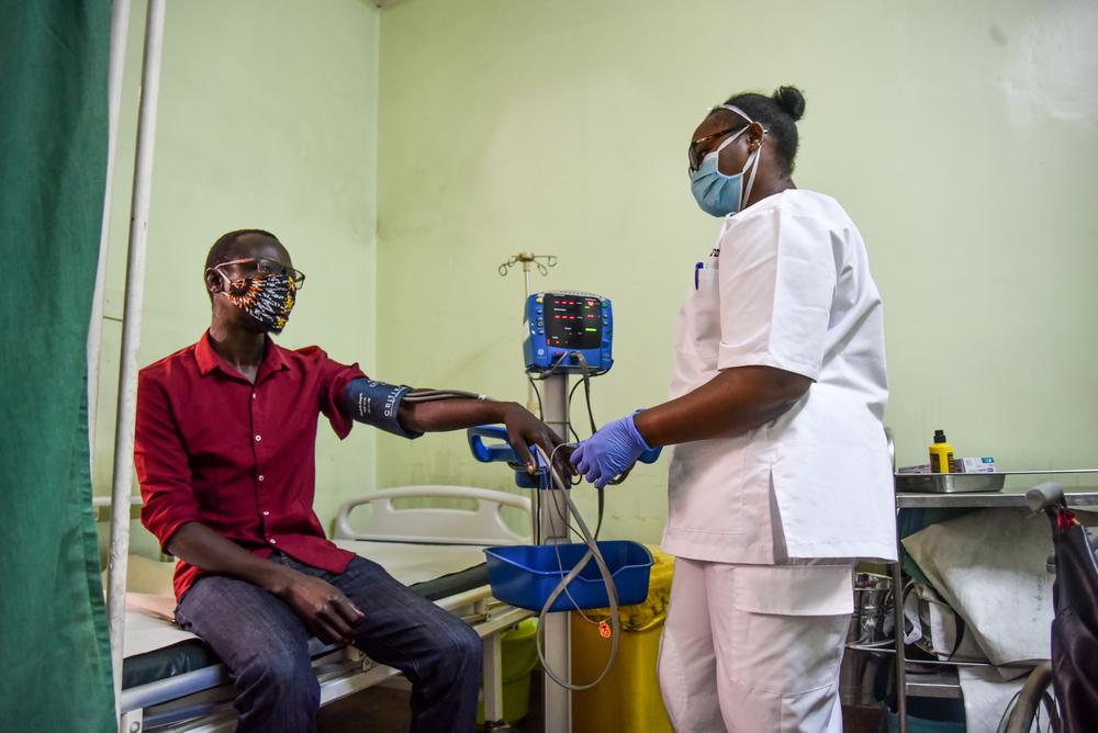 Faith Njeri, an EMT at MSF Lavender House checks vitals of a patient