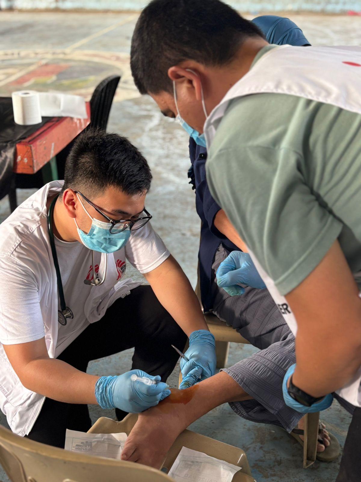 A medical worker attends to an injured individual at the mobile clinic set up in Glan, Sarangani Province, Mindanao, Philippines.