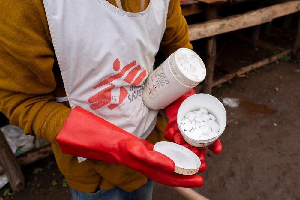 An MSF staff member holds water purification tablets used to provide safe drinking water in Lomera, South Kivu, where a cholera outbreak has followed a rapid population surge due to gold mining.