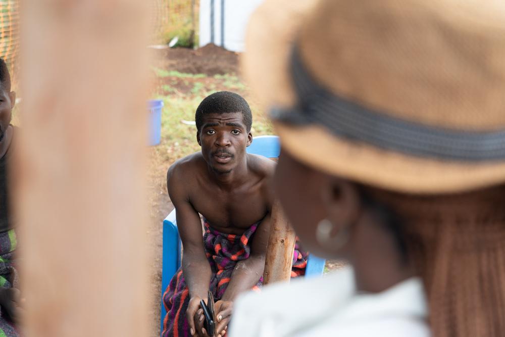 Bonheur Maganda, recently discharged from cholera treatment, sits in Lomera where contaminated lake water used in gold mining exposed him to infection.