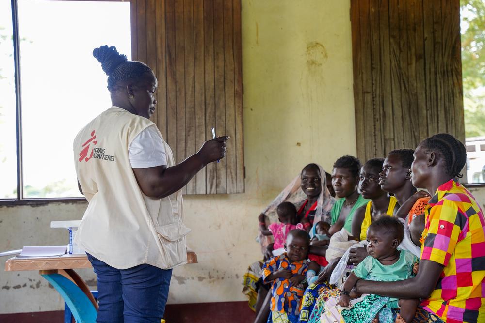 Mary Opani, Community Health Educator, talks with women while they wait for their child to be vaccinated at MSF mobile clinic in Aburoto village, Morobo County, 