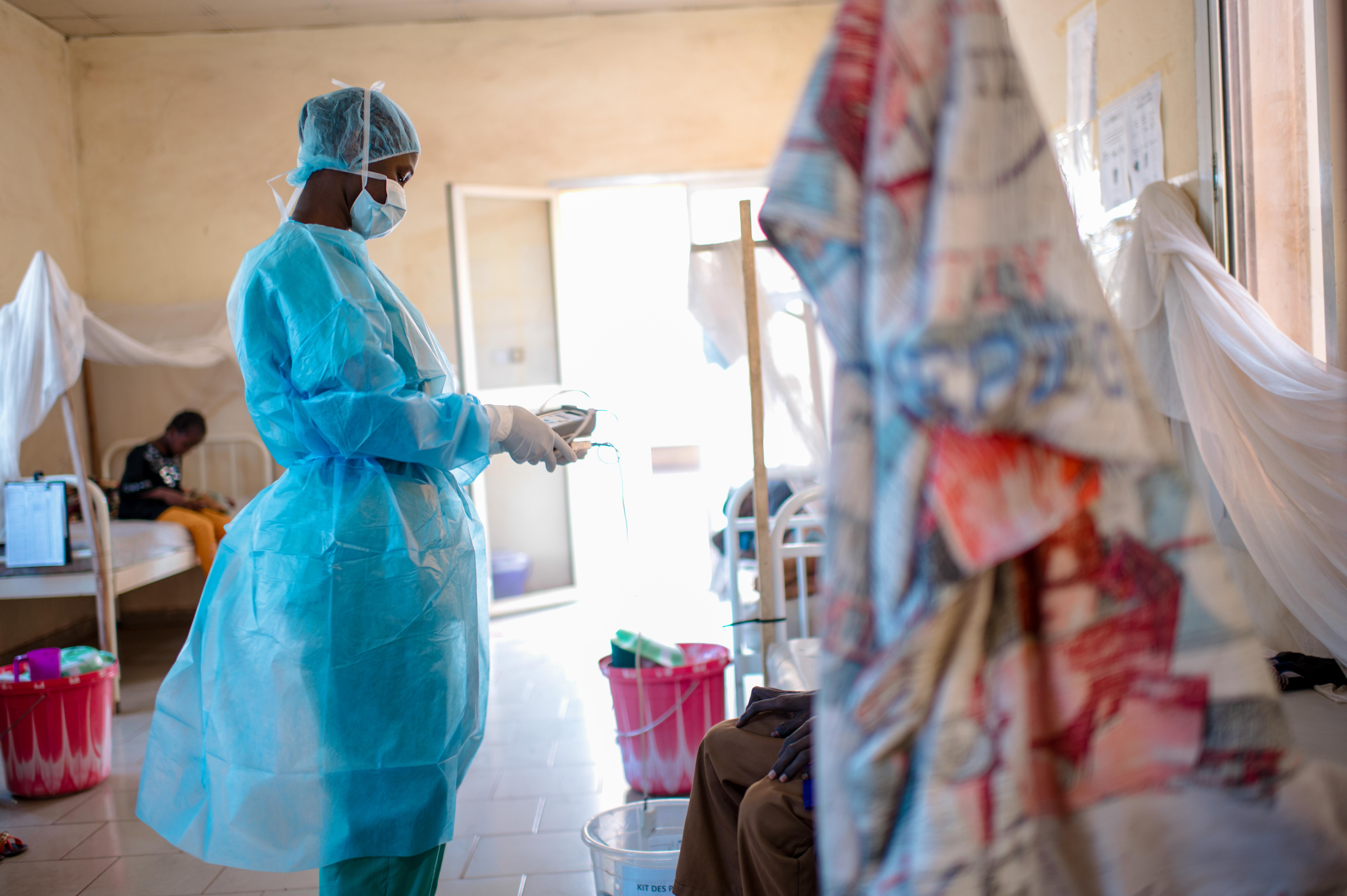 Kankou, a nurse, does a round to check on patients in the morning and to give them their medication against diphtheria at the Centre de Traitement Epidemiologique in Siguiri, Guinea.