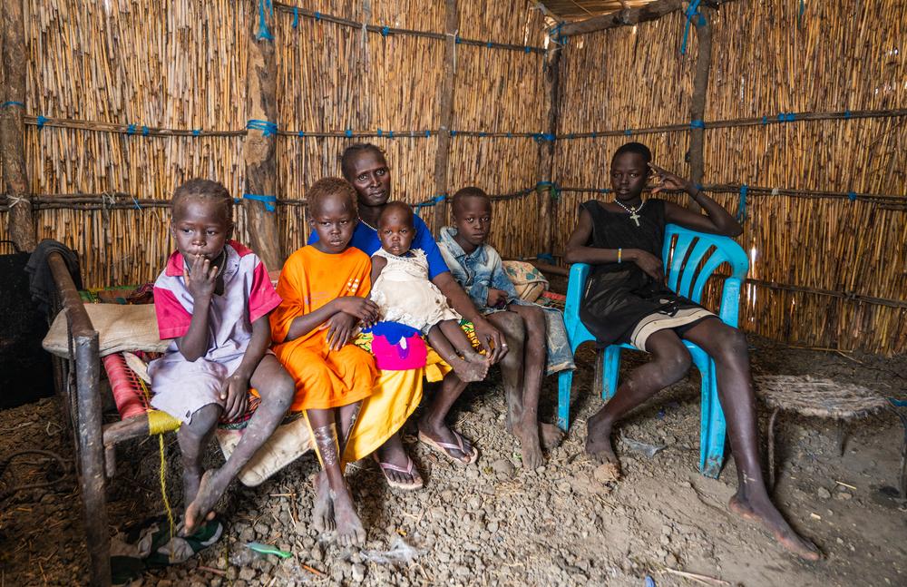 Veronika Nyabol Knom, 39 years old, with 5 of her 6 children in their shelter made of brittle wood and plastic sheets.