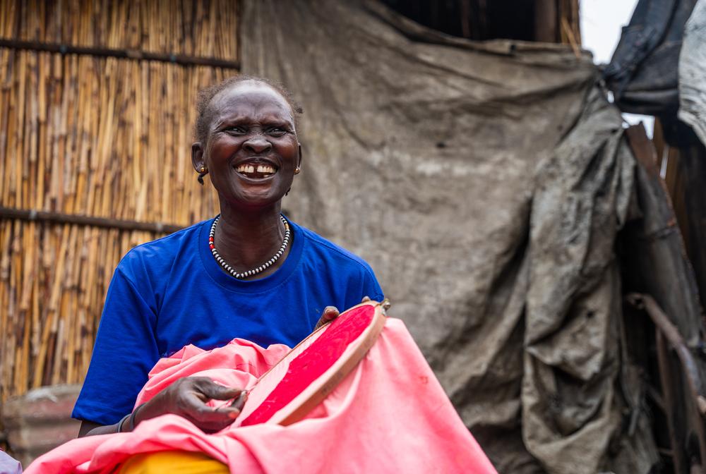 Veronika Nyabol Knom, 39 years old, sewing on a canva to occupy her time in the Bentiu IDP camp.