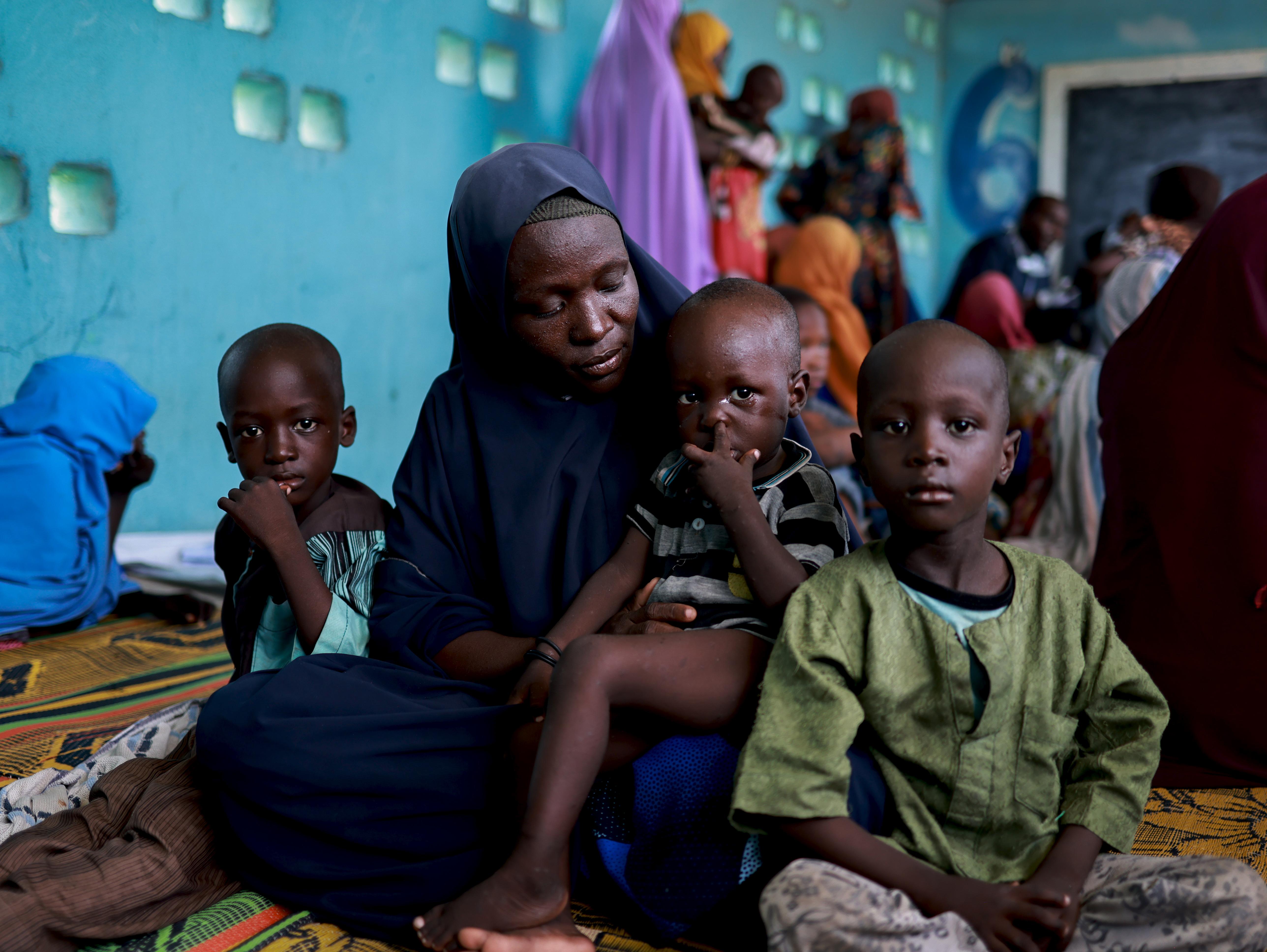 Baana and her children sit at MSF mobile clinic