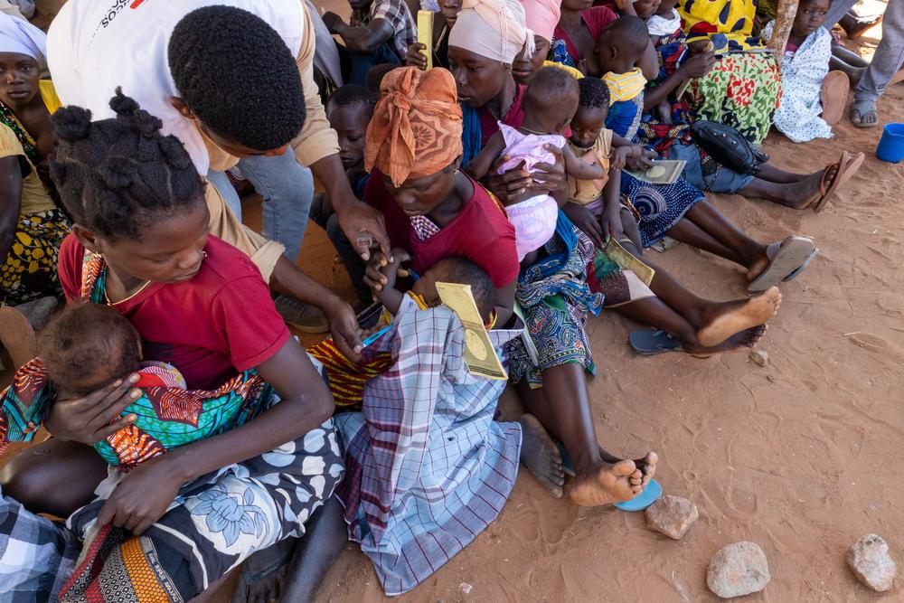 Andre Marcos, an MSF health promoter, assists with the triage of children in the waiting area at Micone temporary resettlement center in Chiure town, southern Cabo Delgado.