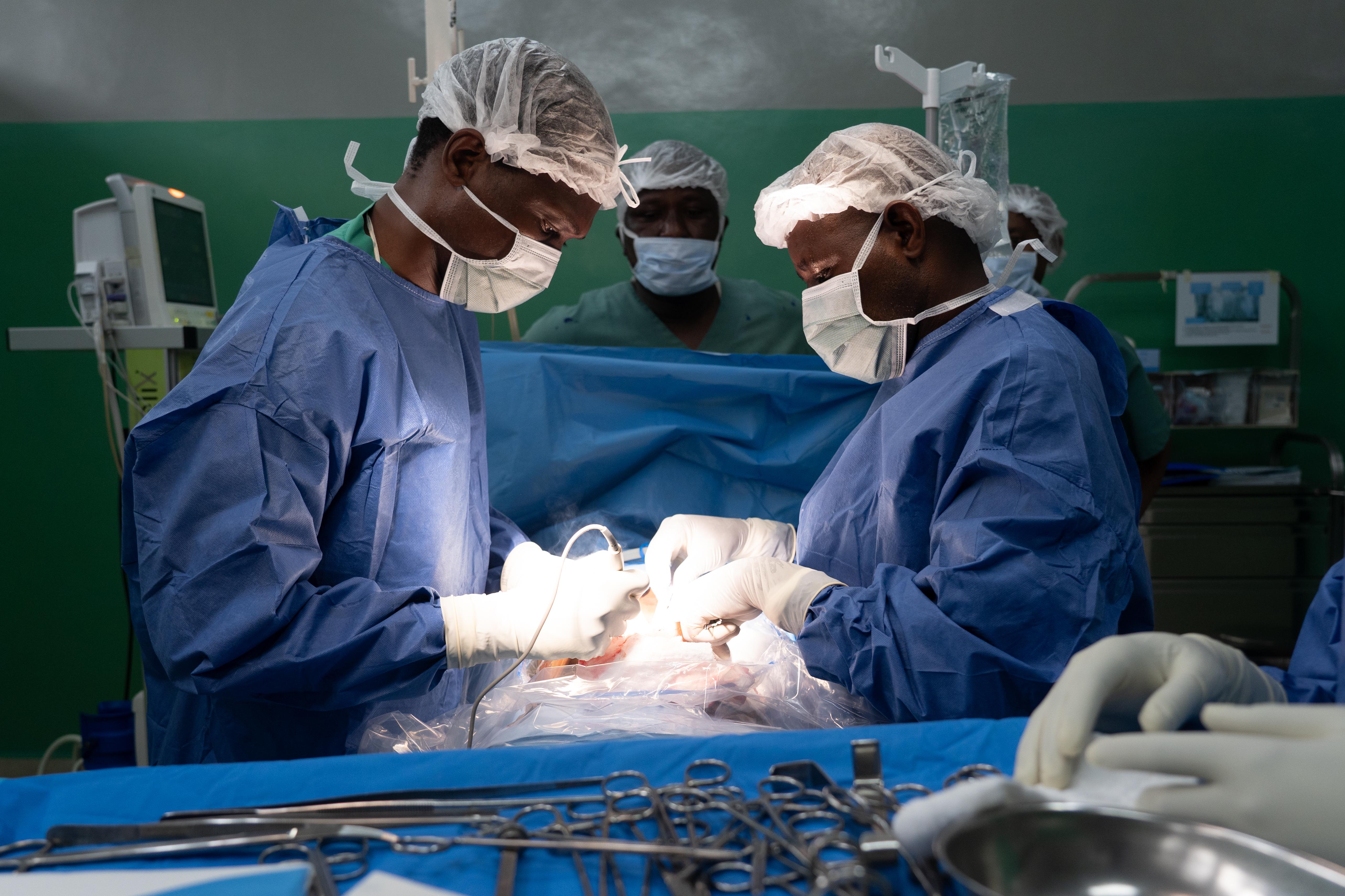 Surgeons at the Rutshuru General Reference Hospital cauterize a wound of a young gunshot victim.