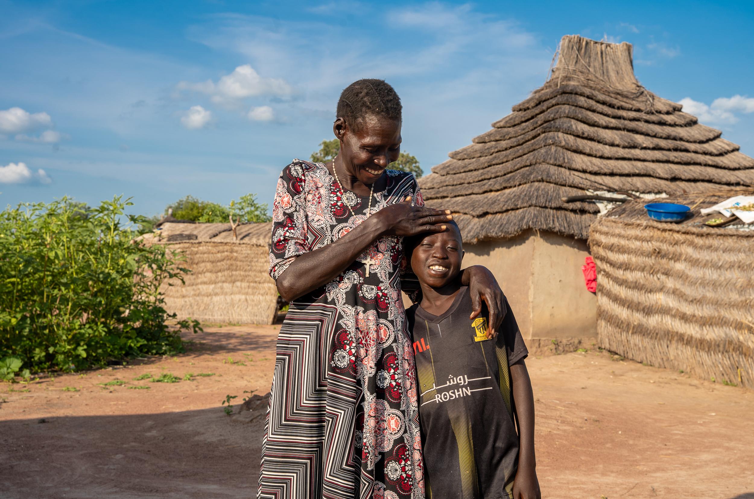 Ajou Mayuen, 12, has type 1 diabetes and frequently goes into diabetic ketoacidosis (DKA), often requiring ICU admission during hospital visits. Due to multiple challenges, the family misses many appointments. They are not enrolled in the insulin pen program and rely on syringes to measure doses from vials stored in clay pots, trying to manage his blood glucose as best they can.