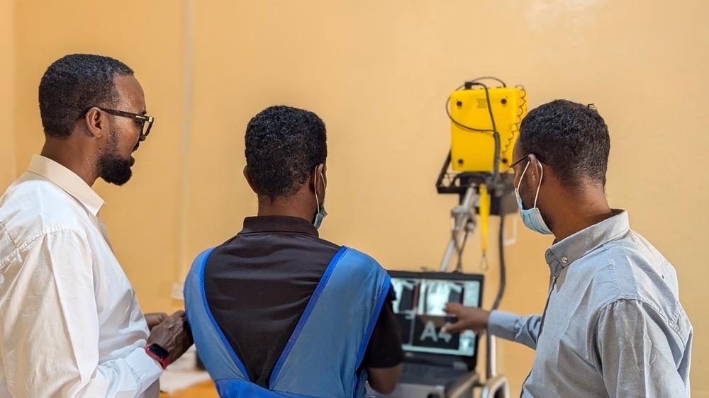 Health workers examine a patient's X-ray on a viewing screen to check for signs of tuberculosis at Galkayo TB Hospital in Galkayo, Mudug region, Somalia. Accurate diagnosis is essential for determining appropriate treatment regimens.