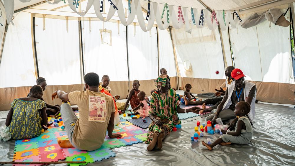 Families and MSF staff during play therapy with children from ITFC
