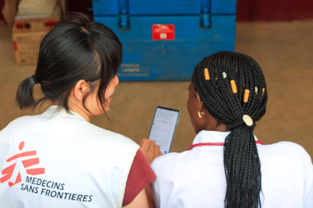 Dre. Anaïs Kale-Mea-Kale and Dre Kana Yamada reviews medical results using the mobile app of the telemedicine case management service at the entrance to the pediatric ward at Carnot Hospital.