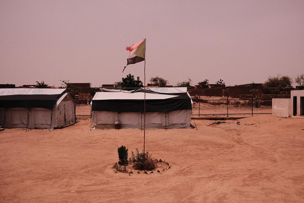 A torn Sudanese flag fly's above a closed primary health care facility in Hashayisa IDP camp., Zalingei. Cuts to international humanitarian funding have meant that IDP's and host communities across Darfur have seen facilities they userd to rely on for primary health care, no longer staffed or equiped.