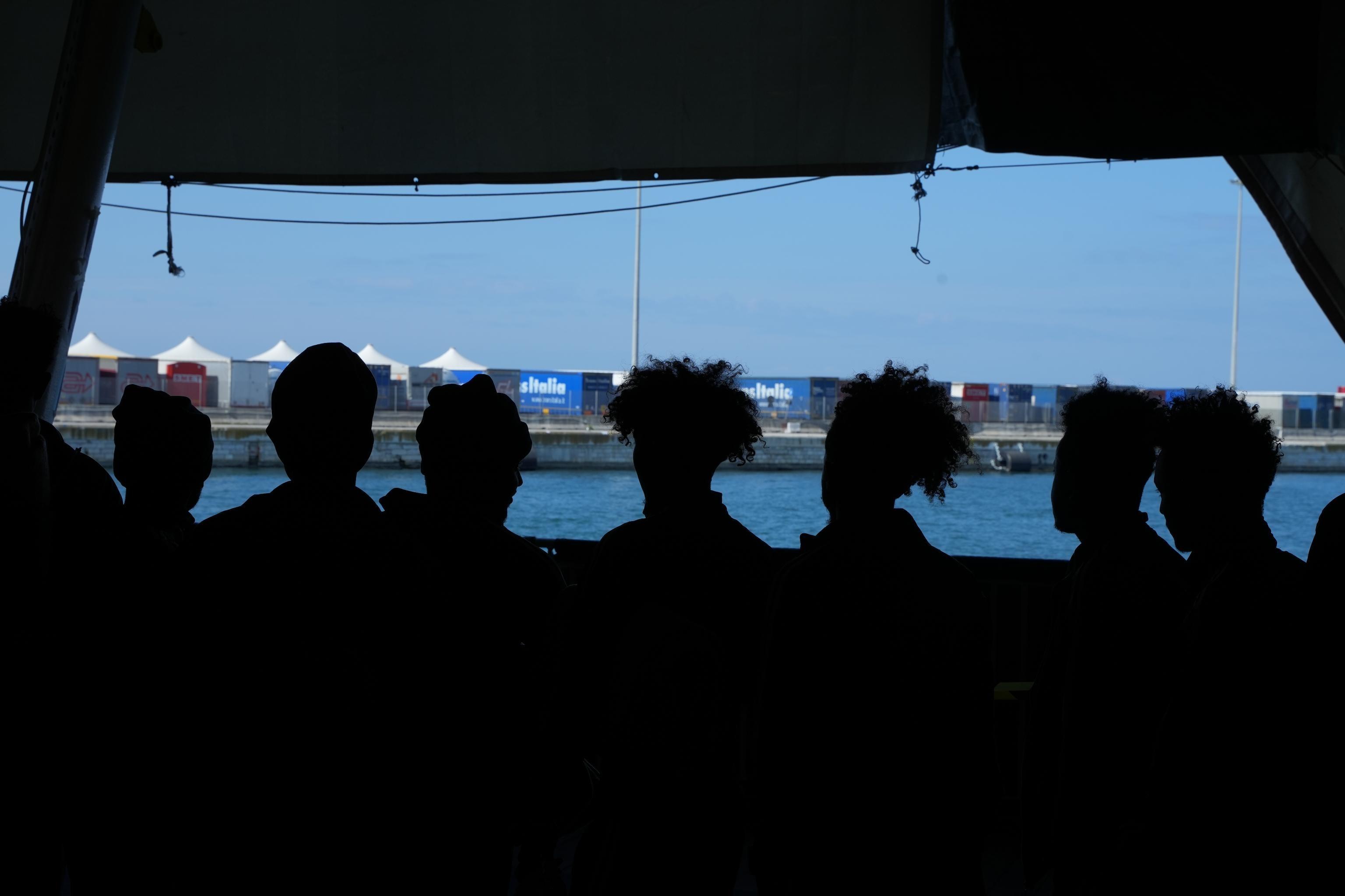 Survivors from Geo Barents disembark in Bari after days at sea; rescue team brings bodies of two deceased young women ashore.