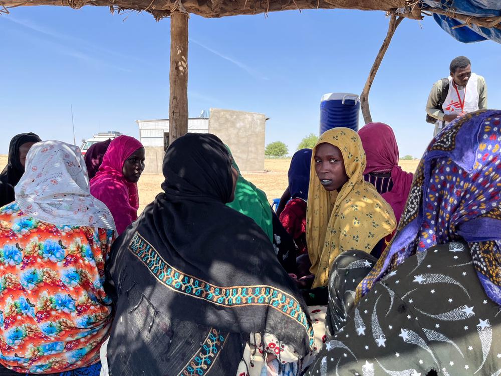 Women and their children wait outside of the ICCM (Integrated Community Case Management) of Bla Kouka, Chad, for malnutrition detection and treatment. Cherif Mohamat Adoum, an MSF health promotor supports the coordination of the activity.