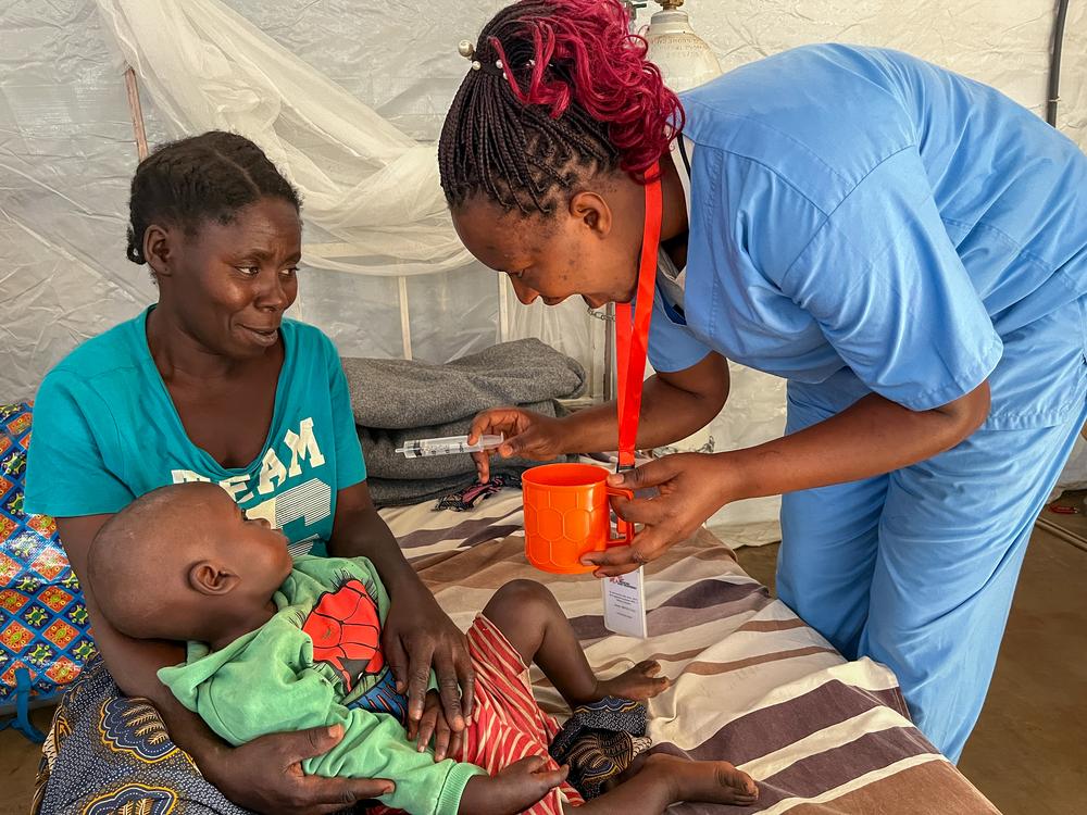 An MSF nurse administers an oral rehydration solution to Yoshua Héritier, aged two and a half, the son of Furaha Simire, aged 45, in the stabilisation room at the MSF healthcare centre in Busuma camp.
