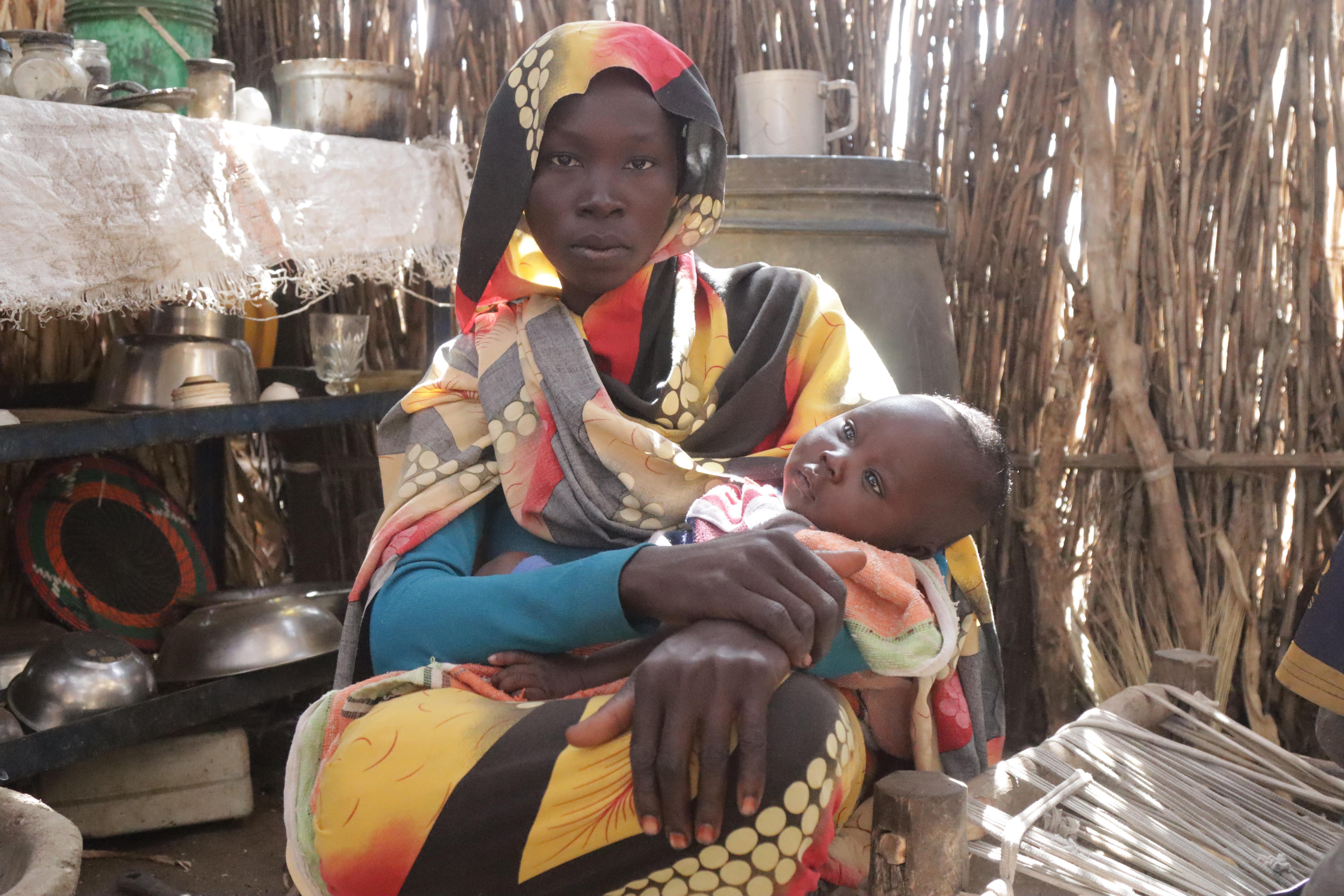 Zahra Abdullah, a 25-year-old displaced woman in Al-Salam camp, stands inside her kitchen after receiving a food basket from MSF in South Darfur.
