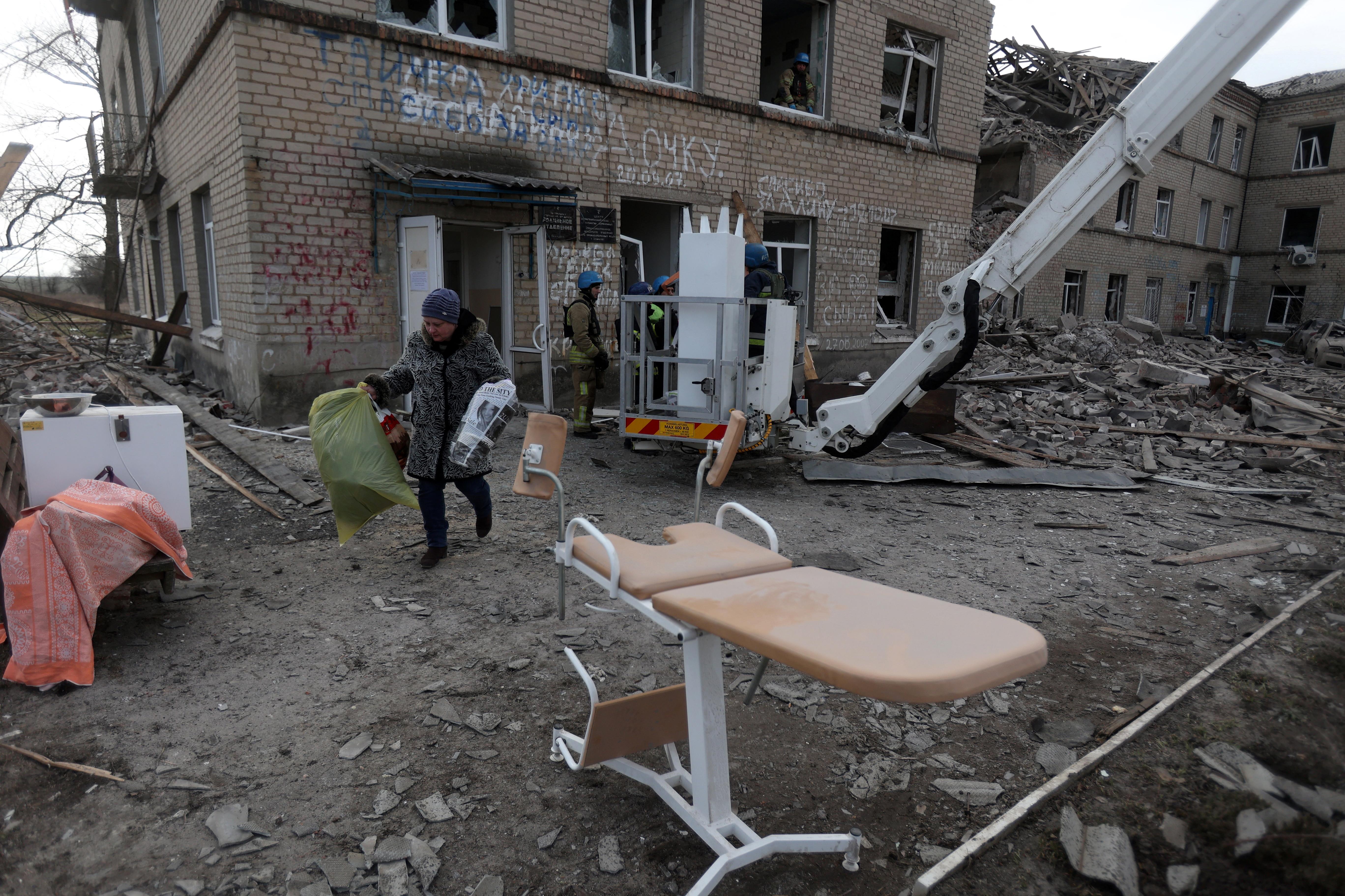 Employees of the State Emergency Service of Ukraine and medical staff evacuate medical equipment from a maternity hospital destroyed by a Russian missile attack in the town of Selydove,
